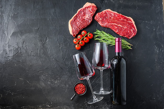 Steaks de boeuf cru Picanha avec assaisonnements et herbes près de bouteille et verre de vin rouge