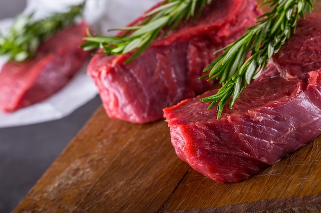 Steaks de boeuf cru avec sel poivre et romarin.