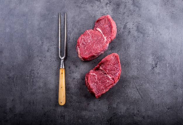 Steaks de boeuf cru sur table en béton.