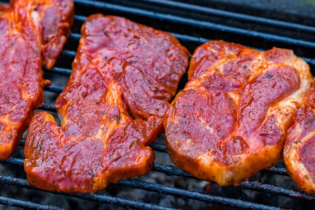 Steaks de boeuf sur le gril avec des flammes.