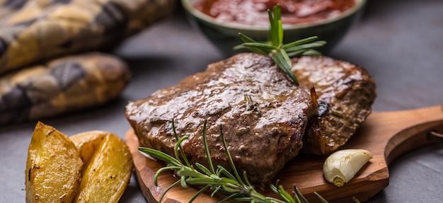 Steaks de boeuf grillés avec sauce barbecue pommes de terre rôties et ros