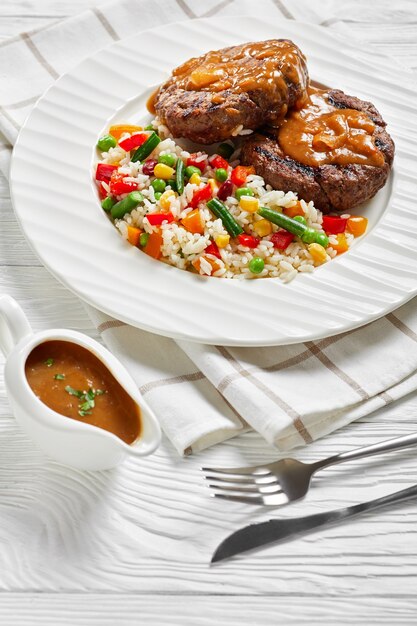 Steaks de boeuf hachés grillés avec sauce aux oignons et riz