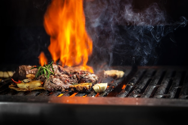 Steaks de boeuf morceaux de viande sur le gril avec des flammes