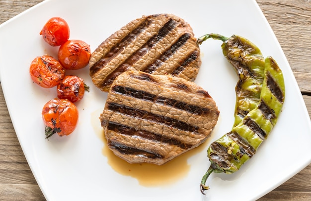 Steaks de boeuf sur la plaque carrée blanche