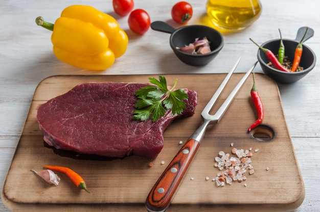 Steaks de boeuf prêts à cuire, surface culinaire. Viande crue fraîche sur planche à découper en bois