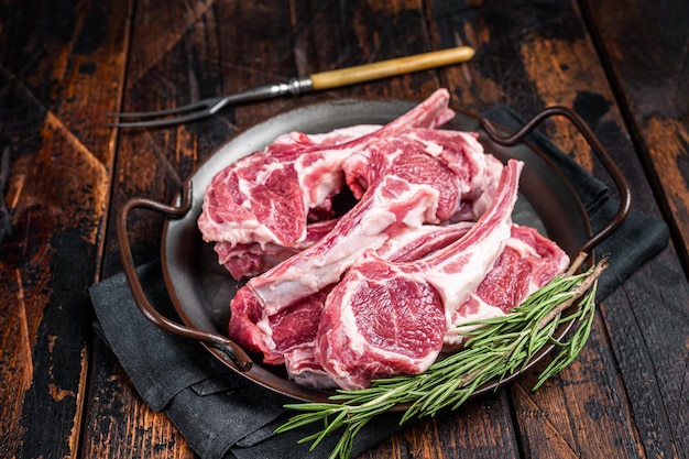 Steaks de côtelette de mouton d'agneau cru escalopes de viande fraîche sur la table de boucher Fond noir Vue de dessus