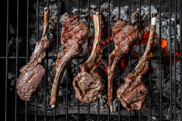 Steaks de côtelettes d'agneau grillés sur barbecue, barbecue en plein air avec feu. Vue de dessus.