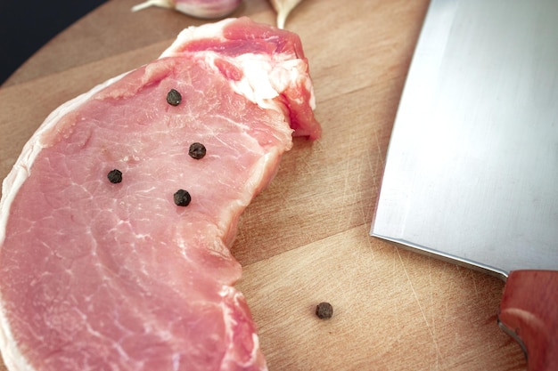 Steaks crus en rangée avec des épices sur une planche de bois vue de dessus à plat