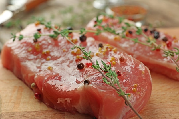 Steaks en marinade avec du thym et de l'ail sur planche de bois