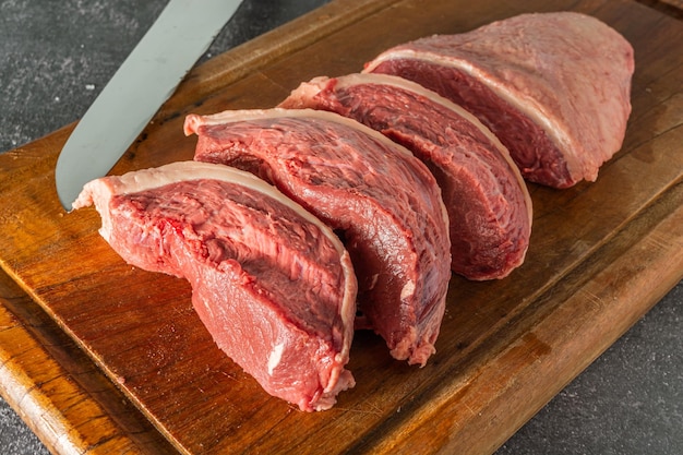 Steaks de picanha crus sur une planche à découper