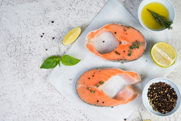 Steaks de poisson rouge marinés pour la cuisson avec des ingrédients sur parchemin