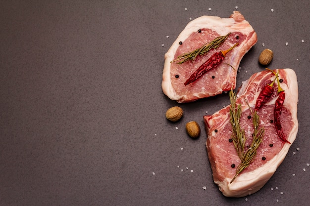 Steaks de porc cru sur table grise