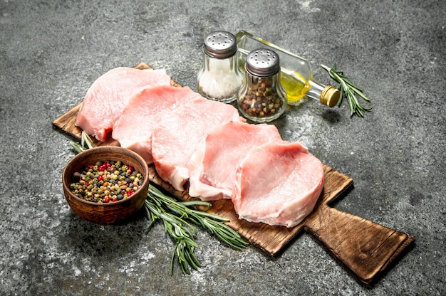 Steaks de porc crus aux herbes et épices.