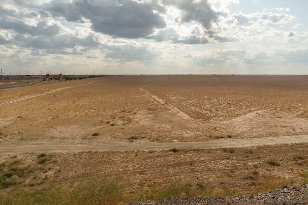 Steppe au Kazakhstan, herbe sèche dans une steppe vide, ciel nuageux