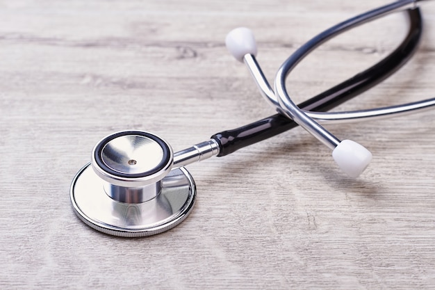 Stéthoscope allongé sur une table en bois. Instrument cardiaque médical.