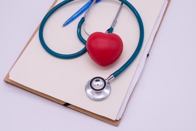 Stéthoscope avec coeur rouge et feuille de carton sur fond blanc