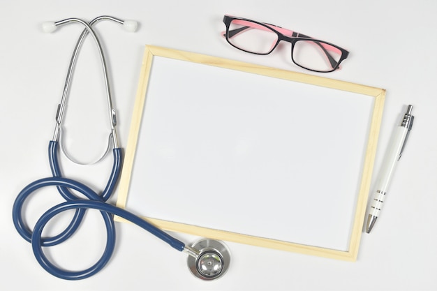 Photo stéthoscope avec lunettes et tableau blanc vierge