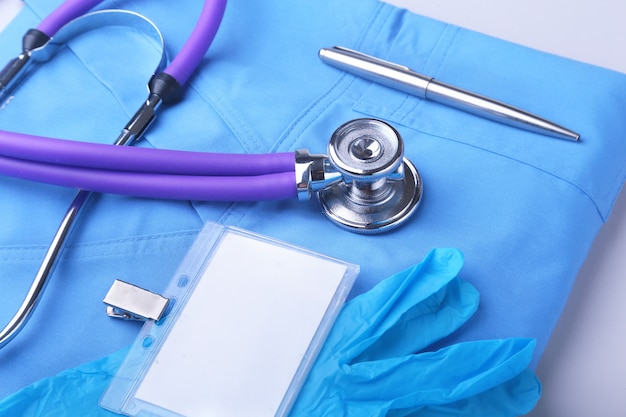 Stéthoscope médical allongé sur un formulaire de médecin bleu et close-up de bloc-notes. l'espace de travail du thérapeute.