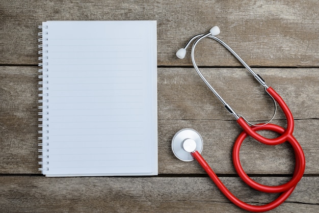 Stéthoscope médical avec cahier sur table en bois