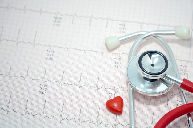 Stéthoscope et mini coeur rouge sur papier électrocardiogramme (ECG / ECG).