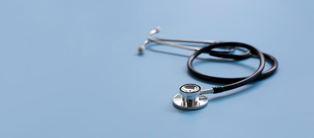 Stéthoscope noir sur fond bleu, concept de soins de santé