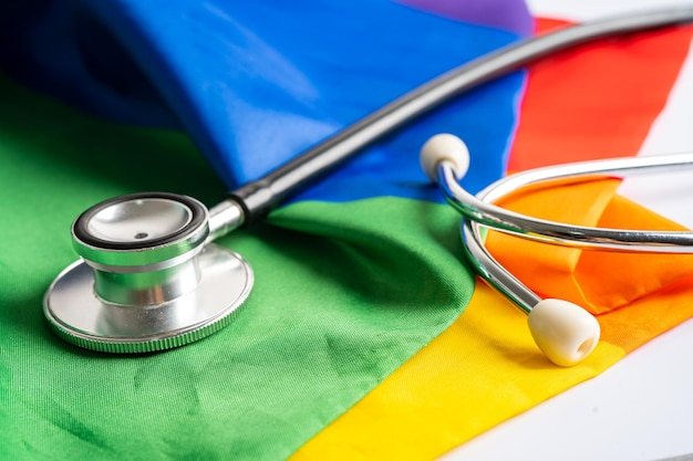 Stéthoscope noir sur fond de drapeau arc-en-ciel symbole du mois de la fierté LGBT célèbre annuellement en juin symbole social des droits de l'homme et de la paix transgenres bisexuels gays lesbiennes