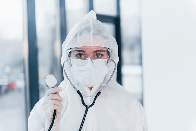 Avec stéthoscope. Portrait de femme médecin scientifique en blouse de laboratoire, lunettes défensives et masque