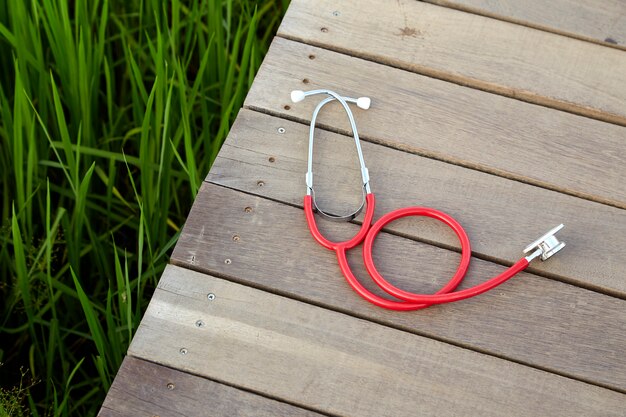 Stéthoscope rouge sur bois extérieur