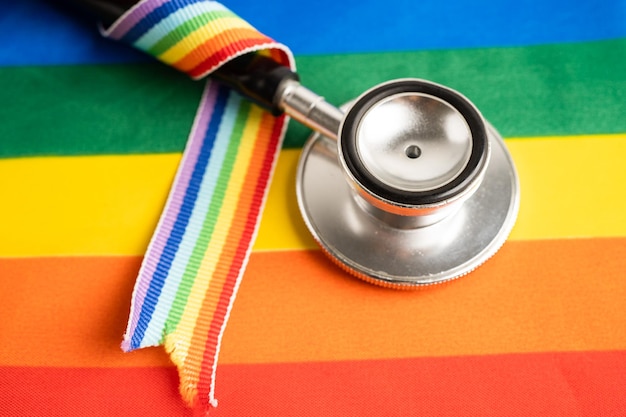 Stéthoscope rouge sur fond de drapeau arc-en-ciel symbole du mois de la fierté LGBT célèbre annuellement en juin symbole social des droits de l'homme et de la paix transgenres bisexuels gays lesbiennes