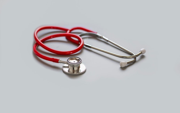 Stéthoscope rouge sur fond gris concept de soins de santé