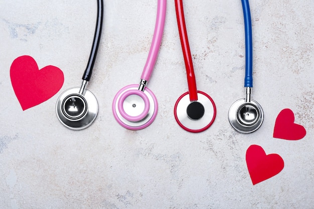 Stéthoscopes et coeurs sur gris. Notion de cardiologie