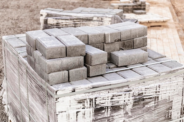 Stockage des dalles sur palettes sur chantier. Dalles en béton prêtes à poser. Entrepôt de produits finis.