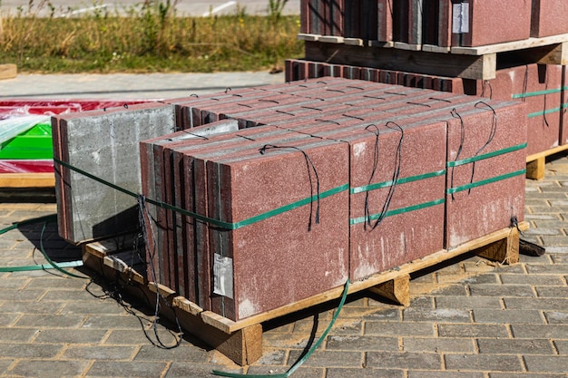 Stockage des dalles sur palettes sur chantier. Dalles en béton prêtes à poser. Entrepôt de produits finis.