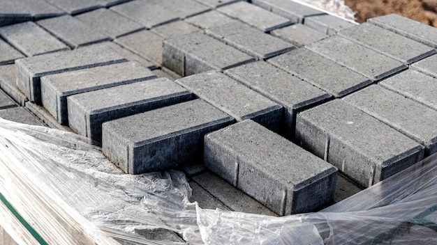 Stockage des dalles sur palettes sur chantier. Dalles en béton prêtes à poser. Entrepôt de produits finis.