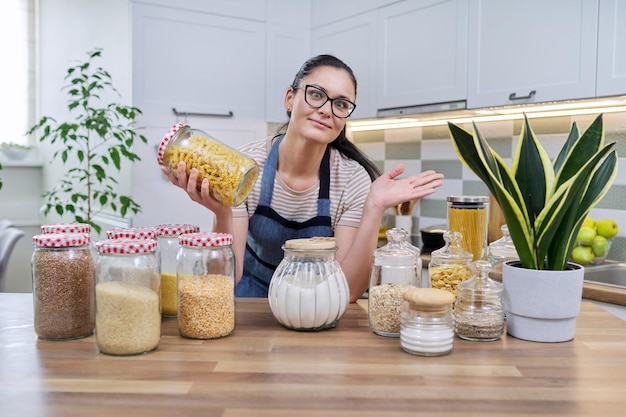 Stockage d'épicerie alimentaire femme souriante regardant la caméra dans la cuisine