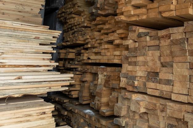 Stockage de planches de bois sous un auvent avec de la neige et de la glace fondue sur le sol