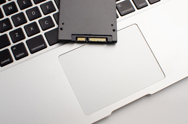 Stockage SSD haute vitesse sur ordinateur portable gris avec technologie SSD Concept performance informatique et innovation et performance Surface blanche SSD avec port et connexion dorée