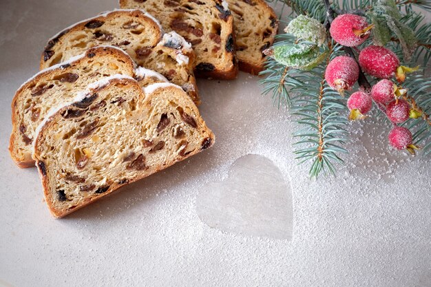 Stollen de Noël à bord de pierre clair avec des brindilles de sapin et des baies