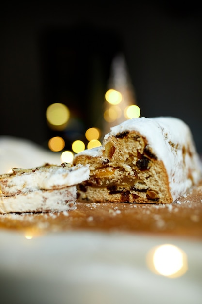 Stollen De Noël En Massepain Traditionnel Fait Maison Sur Fond Blanc, Avec Des Lumières Et Des Décorations De Noël