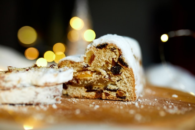 Stollen de Noël en massepain traditionnel fait maison sur fond blanc, avec des lumières et des décorations de Noël