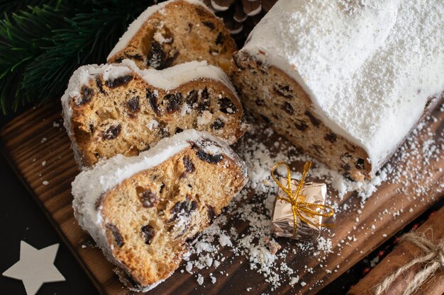 Stollen de Noël traditionnel fait de fruits secs et de noix saupoudrés de sucre en poudre