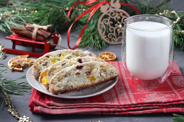 Stollen de Noël en tranches avec des fruits secs et un verre de lait. Gâterie pour le Père Noël. Friandises traditionnelles allemandes. Fermer