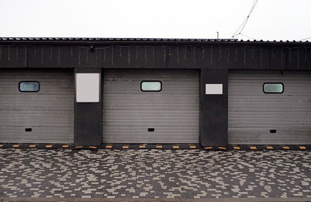 stores enrouleurs de garage. lave-auto fermé, porte automatique à enroulement électrique ou porte push-up. Porte d'obturation ou porte roulante et extérieur de mur de brique.