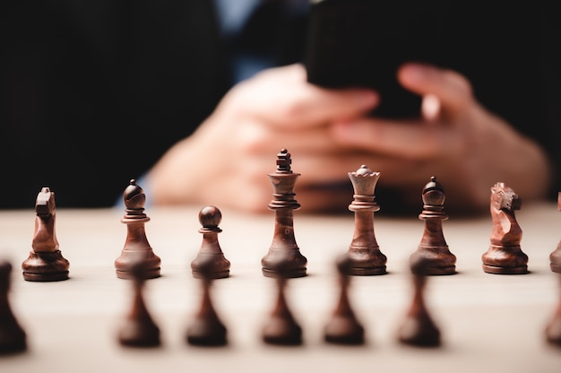 Stratégie d'échecs pour le leadership commercial et l'équipe dans le concept de réussite, compétition de chef de jeu avec défi de puissance de travail d'équipe, pièce de pion jouant à bord, intelligence de victoire de l'échiquier