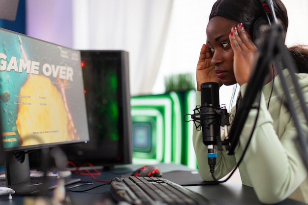 Un streamer africain regrette d'avoir perdu un tournoi de jeu de tir en direct touchant le temple. Joueur professionnel diffusant des jeux vidéo en ligne avec de nouveaux graphismes sur un ordinateur puissant.