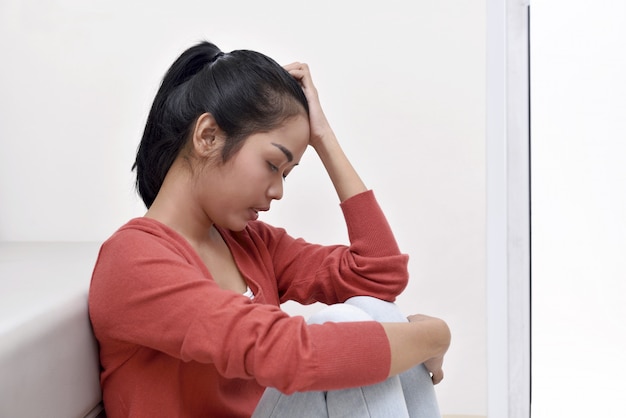 Stress asiatique femme étreignant son genou