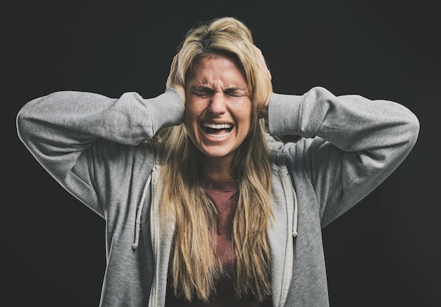 Stress crier ou pleurer femme avec les mains sur les oreilles sur fond noir en studio avec anxiété de santé mentale ou schizophrénie Psychologie dépression ou crier patient en conseil aide asile