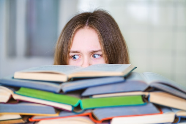 Stressé étudiant collégial fatigué d'apprendre dur avec des livres dans la préparation aux tests d'examens, submergée adolescente de lycée épuisée par des études difficiles ou trop de devoirs, concept cram