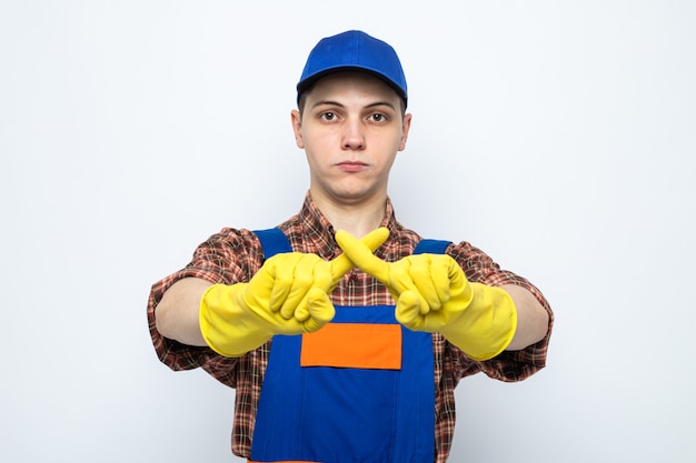 Strict montrant le geste d'aucun jeune homme de nettoyage portant un uniforme et une casquette avec des gants