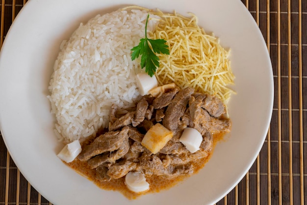 Stroganoff de boeuf avec crème sure à la tomate coeur de riz de palme et extrait de frites Vue de dessus